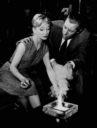 Rex Harrison seems taken aback as Joan gives a small demonstration of witchcraft in the ash tray. September 22, 1955. (Photo by Daily Express).  Copyright: xLondonxExpressxNewsxandxFeaturexServicesx 5513-78878067