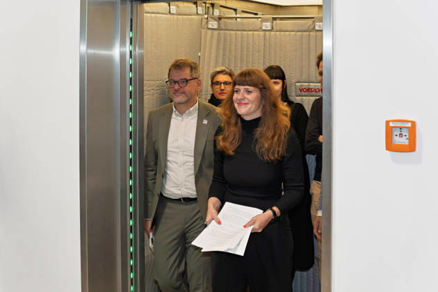 Berlin, 08.10.2026: Kerstin Wolter-Ehling (Die Linke, vorn) und Werner Graf (Bündnis 90 Die Grünen, l.) kommen nach Abschluss der Vorgespräche von Die Linke Berlin, Bündnis 90 Die Grünen Berlin und SPD Berlin aus dem Fahrstuhl zum gemeinsamen Pressestatement im Foyer des Hauses der Statistik. Pressestatement von Linke, Grünen und SPD in Berlin