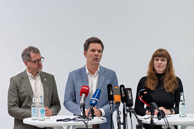 Berlin, 08.10.2026: Steffen Krach (SPD, M.) spricht neben Werner Graf (Bündnis 90 Die Grünen, l.) und Kerstin Wolter-Ehling (Die Linke, r.) beim gemeinsamen Pressestatement nach Abschluss der Vorgespräche ihrer Parteien im Foyer des Hauses der Statistik. Pressestatement von Linke, Grünen und SPD in Berlin