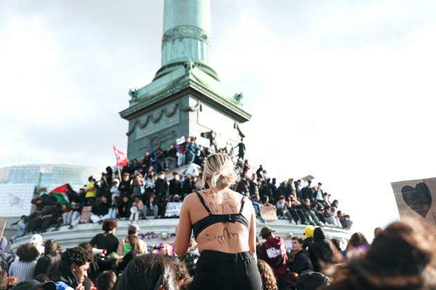 High School And University Student Protest - Paris A protester at Place de la Bastille, in front of the July Column with the inscription macron, fuck your mother on her back, during a nationwide youth demonstration. Nationwide mobilization by high school and university students calling for better teaching and study conditions, increased funding and staffing, an end to overcrowded classrooms and deteriorating infrastructure, and improved access to education, amidst concerns over social inequalities and student financial insecurity in Paris, France, October 8, 2026. Photo by Christophe Michel ABACAPRESS.COM Paris ILE DE FRANCE France  Copyright: xMichelxChristophe ABACAx