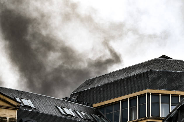 Thick black plumes of smoke rise from fires near Mont des Arts in central Brussels, Belgium, on 9 October 2026, during violent student protests and a trade union demonstration. Hotels and other buildings in the Brussels city centre are visible in the foreground as smoke spreads above the urban skyline.