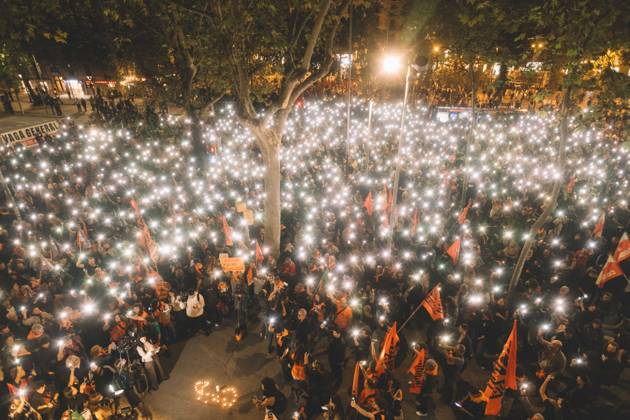 October 9, 2026, Barcelona, Catalonia, Spain: Protesters hold up their phone lights during a minute of silence for Maricarmen in front of the University of Barcelona, next to a banner calling for a general strike. More than a thousand people gathered in Placa Universitat in Barcelona on the evening of October 9, 2026, at a housing rights protest called by tenants and housing unions, including the Sindicat de Llogateres, under the slogan For Olga and Maricarmen: the housing business kills . The protest honoured MARICARMEN, an 87-year-old woman who died in a Madrid hospital on October 7, two weeks after being evicted from the rented flat where she had lived since 1956, and OLGA, a woman from L Hospitalet de Llobregat who took her own life - ZUMAs392 20261009_zip_s392_001 Copyright: xFabianxSuspensivox