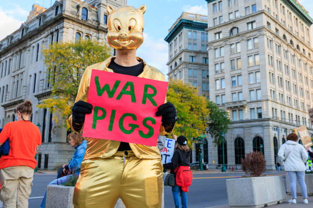 October 9, 2026, Syracuse, Ny, USA: A person in a gold pig mask holding a sign in opposition to war at the protest against the Trump rally being held at the Oncenter. Syracuse USA  - ZUMAh195 20261009_znp_h195_005 Copyright: xAlexxHamerx
