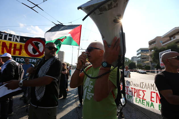 October 10, 2026, Athens, Attica, GREECE: A protester speaks into a megaphone as Palestinian flags and anti-war banners are displayed behind him. Athens GREECE  - ZUMAx103 20261010_zip_x103_027 Copyright: xHarrisxXanthopoulosx