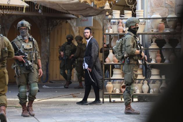 Israeli settlers enter Hebron Old City under military protection HEBRON, OCCUPIED WEST BANK, OCTOBER 10, 2026: Israeli settlers enter Hebron s Old City under the protection of Israeli forces during an organized visit to the area. Israeli soldiers deployed along streets and around the group as settlers moved through the Old City, where Israeli settlers and Palestinian residents live in close proximity amid longstanding tensions and movement restrictions. HEBRON Palestine, State of Copyright: x xMosabxshawerx xJNAxPressx