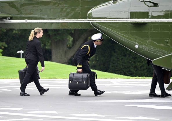 Aides carrying the briefcases referred to as the football board Marine One to accompany United States President Donald J Trump as he departs the South Lawn of the White House in Washington, DC, en route Clarksville, Tennessee on Saturday, October 10, 2026. The President will participate in a campaign rally for Tennessee Republican candidates on the ballot in November.  WAX20261010201 RONxSACHS