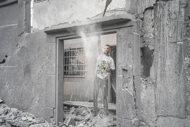 Israeli attack on Az-Zawayda area in Gaza DEIR AL-BALAH, GAZA, PALESTINE - OCTOBER 11: A man stands in the doorway of a damaged building as dust falls around him following an Israeli airstrike targeting a building belonging to the Buheysi family in the town of Az-Zawayda, near Deir al-Balah in the central Gaza Strip, on October 11, 2026. Israeli forces carried out the strike despite the ceasefire, destroying the targeted building and damaging surrounding structures. Adam Bilal Anadolu Deir Al-Balah Gaza. Editorial use only. Please get in touch for any other usage.  Copyright: x2026xAnadoluxAdamxBilalx