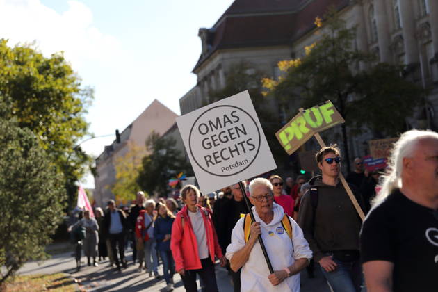 Eine Demonstrantin läuft mit Schild Omas gegen Rechts Potsdam in der Dortustraße während einer Demonstration für die Überprüfung rechtsextremer Parteien durch das Bundesverfassungsgericht, Potsdam, 10. Oktober 2026. Prüf-Demo in Potsdam
