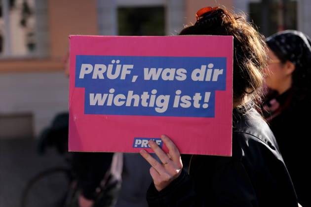 Eine Demonstrantin läuft mit Schild Prüf, was dir wichtig ist! in der Charlottenstraße während einer Demonstration für die Überprüfung rechtsextremer Parteien durch das Bundesverfassungsgericht, Potsdam, 10. Oktober 2026. Prüf-Demo in Potsdam