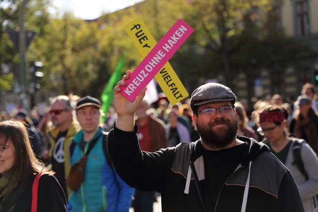 Ein Demonstrant läuft mit Schild fUEr Vielfalt Kreuz ohne Haken in der Charlottenstraße während einer Demonstration für die Überprüfung rechtsextremer Parteien durch das Bundesverfassungsgericht, Potsdam, 10. Oktober 2026. Prüf-Demo in Potsdam