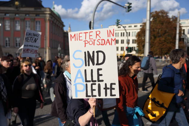 Eine Demonstrantin läuft mit Schild Mieter in Potsdam Sind Alle Pleite auf der Langen Brücke während einer Demonstration gegen Wohnungsnot und steigende Mieten, Potsdam, 10. Oktober 2026. Mieten-Demo in Potsdam