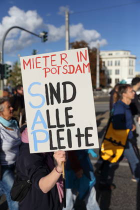 Eine Demonstrantin läuft mit Schild Mieter in Potsdam Sind Alle Pleite auf der Langen Brücke während einer Demonstration gegen Wohnungsnot und steigende Mieten, Potsdam, 10. Oktober 2026. Mieten-Demo in Potsdam