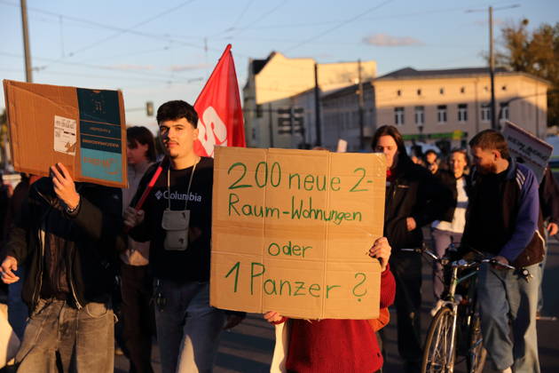 Demonstranten laufen mit Schild 200 neue 2-Raum-Wohnungen oder 1 Panzer? in der Friedrich-Engels-Straße während einer Demonstration gegen Wohnungsnot und steigende Mieten, Potsdam, 10. Oktober 2026. Mieten-Demo in Potsdam