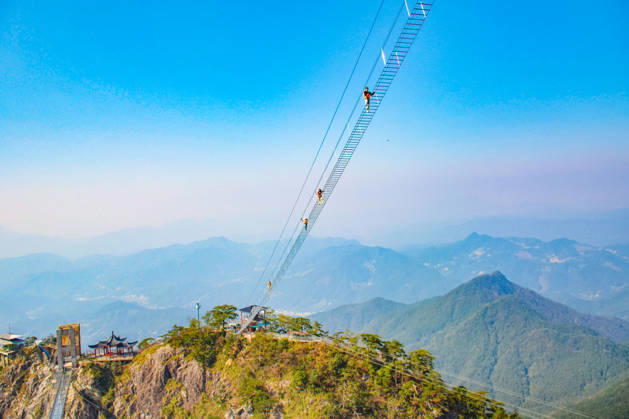China Sky Ladder Challenger Tourists climb up a 250-meter-long soft ladder between two mountains in Mingtangshan Scenic Area in Yuexi county in central China s Anhui province, Sunday, Oct. 11, 2026. The rope ladder has 620 steps and a vertical distance of 365 meters. It opened to tourists in June this year, and quickly became a tourist attraction., Credit:stringer Utuku Feature China Avalon CHINA, ANHUI, YUEXI  Copyright: xstringerx xUtuku FeaturexChinax xAvalonx 1142342727