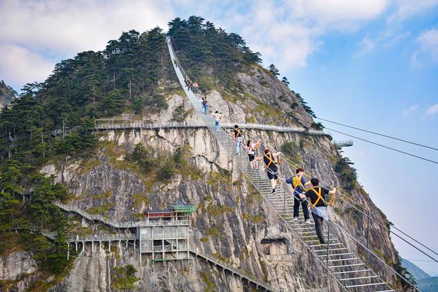 China Sky Ladder Challenger Tourists climb up a 250-meter-long soft ladder between two mountains in Mingtangshan Scenic Area in Yuexi county in central China s Anhui province, Sunday, Oct. 11, 2026. The rope ladder has 620 steps and a vertical distance of 365 meters. It opened to tourists in June this year, and quickly became a tourist attraction., Credit:stringer Utuku Feature China Avalon CHINA, ANHUI, YUEXI  Copyright: xstringerx xUtuku FeaturexChinax xAvalonx 1142342734