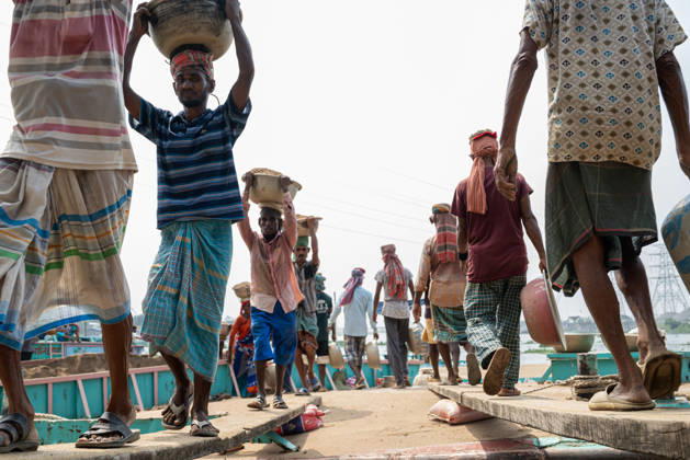 Migrant Workers Unload Sand Workers unload sand at a riverside site in Gabtoli, Dhaka, Bangladesh, on October 11, 2026. Many have left rural communities in search of employment in the capital, where daily labor provides a source of income but often involves strenuous work and limited financial security. Dhaka Bangladesh  Copyright: xBipulxAhmedx originalFilename: mondol-notitle261011_npaLr.jpg