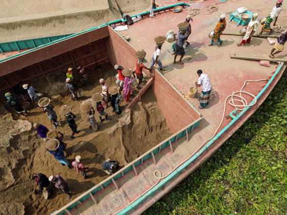 Migrant Workers Unload Sand Workers unload sand at a riverside site in Gabtoli, Dhaka, Bangladesh, on October 11, 2026. Many have left rural communities in search of employment in the capital, where daily labor provides a source of income but often involves strenuous work and limited financial security. Dhaka Bangladesh  Copyright: xBipulxAhmedx originalFilename: mondol-notitle261011_npNve.jpg