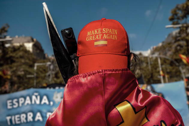 October 12, 2026, Barcelona, Catalonia, Spain: A demonstrator wearing a Make Spain Great Again cap and draped in a Spanish flag is seen during a rally marking SpainÃ¢â‚¬â ¢s National Day. Barcelona Spain - ZUMAo105 20261012_fap_o105_013 Copyright: xMatthiasxOesterlex