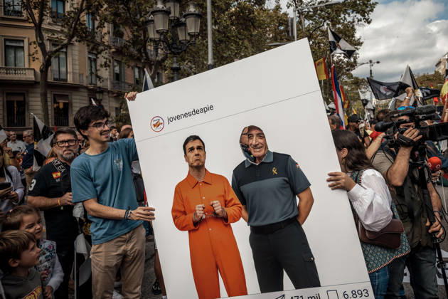 October 12, 2026, Barcelona, Catalonia, Spain: A demonstrator poses with his face through a cutout in a placard depicting Spanish Prime Minister Pedro SoÂ¡nchez in an orange prison uniform during a rally marking SpainÃ¢â‚¬â ¢s National Day. Barcelona Spain - ZUMAo105 20261012_fap_o105_015 Copyright: xMatthiasxOesterlex