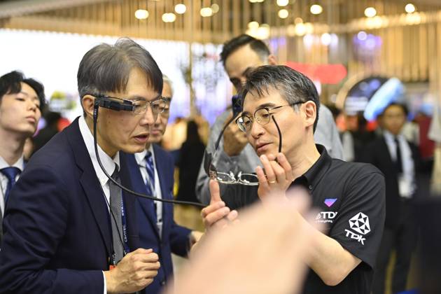 Japan showcases emerging technologies at CEATEC 2026 CHIBA, JAPAN - OCTOBER 13: A visitor tries on a prototype of smart glasses featuring Meta-Optic Mirror technology developed by Japanese electronics company TDK during CEATEC 2026 at Makuhari Messe in Chiba, Japan, October 13, 2026. The prototype uses an ultra-thin optical mirror to direct projected images onto the retina, with TDK aiming to develop more compact and conventional-looking smart glasses. David Mareuil Anadolu Chiba Japan. Editorial use only. Please get in touch for any other usage.  Copyright: x2026xAnadoluxDavidxMareuilx