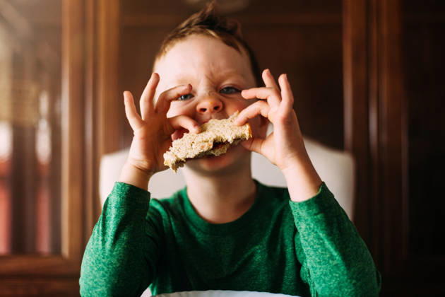 Silly young boy making a funny face while eating a sandwich Tulsa, Oklahoma, United States CR_KRRY261009-2124133-01 ,model released, Symbolfoto ,property released