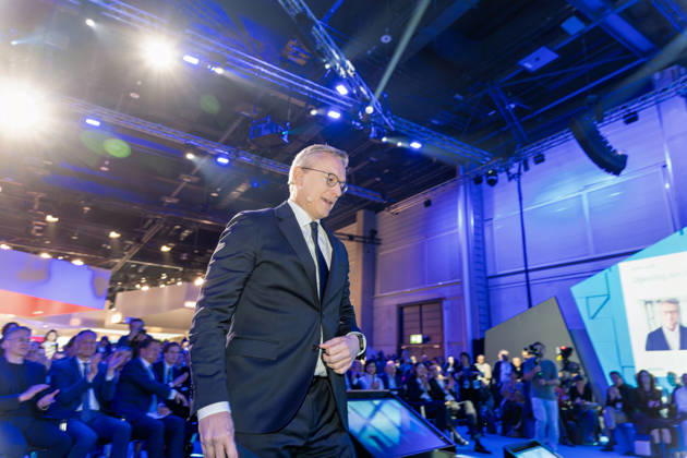 Berlin, 13.10.2026: Bundesdigitalminister Karsten Wildberger geht unter dem Applaus des Publikums zur Bühne der Smart Country Convention in der Halle hub27, im Hintergrund kündigt eine Leinwand seinen Eröffnungsbeitrag an. Karsten Wildberger ist seit Mai 2025 Bundesminister für Digitales und Staatsmodernisierung und leitet das damals neu geschaffene Ministerium, das die Digitalisierung von Staat und Verwaltung bündeln soll; zuvor war der Manager Vorstandschef des Elektronikhändlers Ceconomy (MediaMarkt und Saturn). Die Smart Country Convention (SCCON) ist die Kongressmesse für die Digitalisierung des öffentlichen Sektors und wird vom Digitalverband Bitkom gemeinsam mit der Messe Berlin veranstaltet. Vom 13. bis 15. Oktober 2026 tref