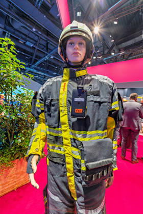 Berlin, 13.10.2026: Eine Schaufensterpuppe in Feuerwehr-Einsatzkleidung mit Helm und Funkgerät steht am Messestand der Deutschen Telekom auf der Smart Country Convention in der Halle hub27. Der Konzern zeigt dort unter dem Namen T Mission Lösungen für einsatzkritische Kommunikation von Behörden und Organisationen mit Sicherheitsaufgaben wie Feuerwehr, Polizei und Rettungsdiensten. Die Smart Country Convention (SCCON) ist die Kongressmesse für die Digitalisierung des öffentlichen Sektors und wird vom Digitalverband Bitkom gemeinsam mit der Messe Berlin veranstaltet. Vom 13. bis 15. Oktober 2026 treffen sich in der Halle hub27 Vertreter aus Bund, Ländern und Kommunen mit Unternehmen der Digitalwirtschaft, um über digitale Verwaltung,