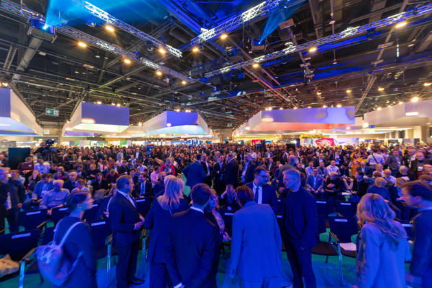 Berlin, 13.10.2026: Hunderte Besucher füllen kurz vor Beginn des Eröffnungsprogramms die Zuschauerreihen vor der Hauptbühne der Smart Country Convention in der Halle hub27, wo anschließend unter anderem Bundesdigitalminister Karsten Wildberger sprach. Die Smart Country Convention (SCCON) ist die Kongressmesse für die Digitalisierung des öffentlichen Sektors und wird vom Digitalverband Bitkom gemeinsam mit der Messe Berlin veranstaltet. Vom 13. bis 15. Oktober 2026 treffen sich in der Halle hub27 Vertreter aus Bund, Ländern und Kommunen mit Unternehmen der Digitalwirtschaft, um über digitale Verwaltung, Smart City und digitale Souveränität zu diskutieren. Volles Haus vor dem Bühnenprogramm der SCCON