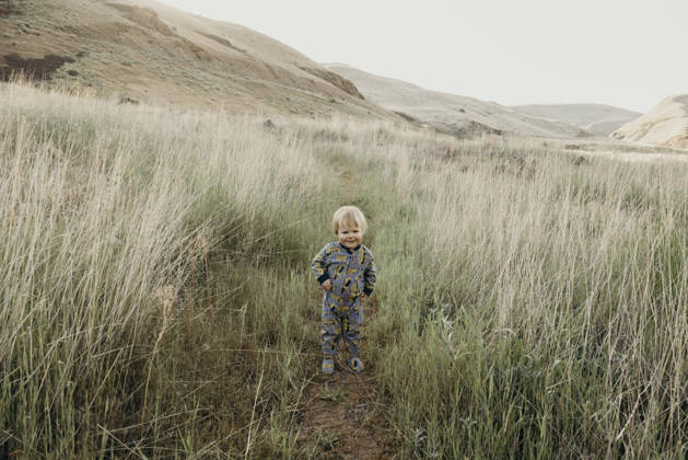 Cute toddler boy standing on a path in a big grassy field The Dalles, Oregon, United States CR_XICZ261001B9-2131818-01 ,model released, Symbolfoto ,property released