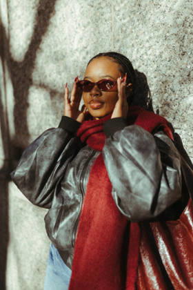 Stylish young woman adjusts her red sunglasses outdoors Cape Town, Western Cape, South Africa CR_YNJN261001-2126858-01 ,model released, Symbolfoto ,property released