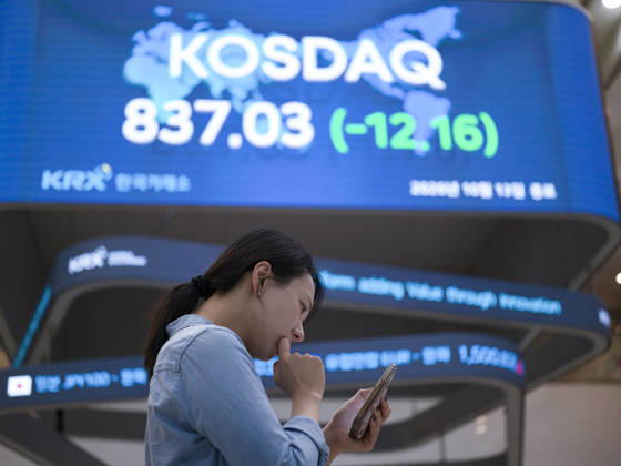 South Korea Stocks Plunge As KOSPI Drops Sharply At KRX In Seoul A Korea Exchange (KRX) employee looks at her smartphone in front of a board displaying the closing KOSDAQ index at 837.03 (-12.16) in Yeouido, Seoul, South Korea, on October 13, 2026. Seoul Seoul South Korea  Copyright: xChrisxJungx originalFilename: jung-southkor261013_npud2.jpg