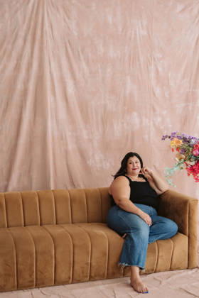 Joyful Woman Laughing on a Vintage Sofa Surrounded by Colorful Flowers Cincinnati, Ohio, United States CR_QUNR260930-2131835-01 ,model released, Symbolfoto ,property released