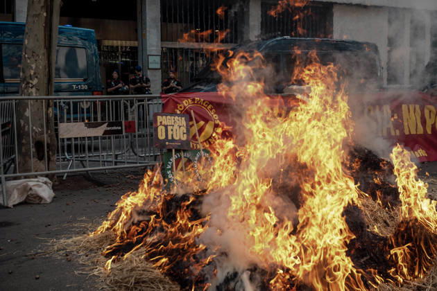 October 14, 2026, Barcelona, Catalonia, Spain: Flames engulf a pile of burning hay outside the Catalan Agriculture Ministry during a farmers protest in Barcelona under the slogan Without Farmers: No Country, No Future demanding fair prices, lower fuel costs, protection against unfair competition from imports and measures to address the economic pressures facing the agricultural sector. Barcelona Spain  - ZUMAo105 20261014_fap_o105_010 Copyright: xMatthiasxOesterlex
