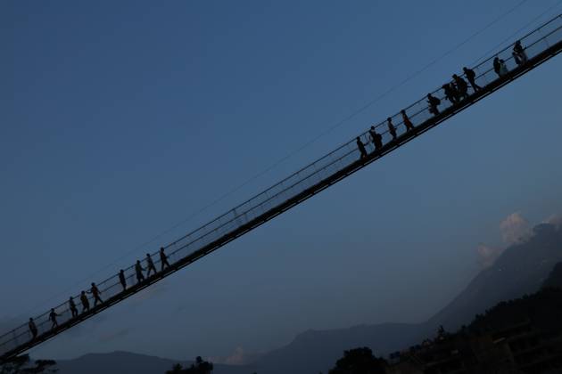 Nepal Bridge Restores Flood-Hit Access NUWAKOT, NEPAL, OCTOBER 14, 2026: Residents cross a newly built suspension bridge over the Trishuli River in Nuwakot, restoring access between communities affected by flash floods. Flooding destroyed bridges and damaged roads in the district, disrupting travel and access to essential services. NUWAKOT Nepal Copyright: x xShankarxBhujelx xJNAxPressx