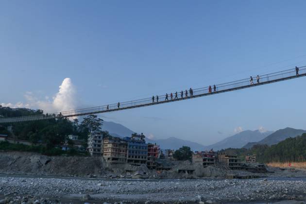 October 14, 2026, Nuwakot, Nepal: NUWAKOT, NEPAL, OCTOBER 14, 2026: Residents cross a newly built suspension bridge over the Trishuli River in Nuwakot, restoring access between communities affected by flash floods. Flooding destroyed bridges and damaged roads in the district, disrupting travel and access to essential services. Nuwakot Nepal - ZUMAq101 20261014_zna_q101_127 Copyright: xShankarxBhujelx