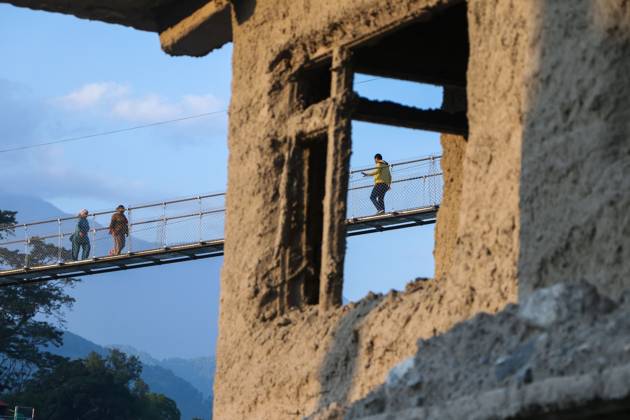 October 14, 2026, Nuwakot, Nepal: NUWAKOT, NEPAL, OCTOBER 14, 2026: Residents cross a newly built suspension bridge over the Trishuli River in Nuwakot, restoring access between communities affected by flash floods. Flooding destroyed bridges and damaged roads in the district, disrupting travel and access to essential services. Nuwakot Nepal - ZUMAq101 20261014_zna_q101_132 Copyright: xShankarxBhujelx