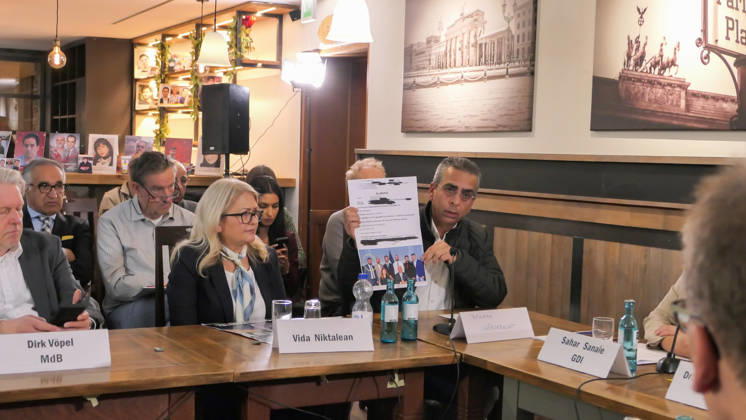 October 14, 2026, Berlin, Germany: Human rights witness, Behnam Vafa Seresht seen holding up documented evidence of threats and harassment by supporters of Reza Pahlavi while seated beside witness, Vida Niktalean and MP Dirk Vöpel . The conference, titled Iran in Crisis: The Democratic Solution and Germany s Responsibility, was organized by the German Solidarity Committee for a Free Iran (DSFI) and the Association of German-Iranians (GDI) at Hopfingerbräu am Brandenburger Tor in Berlin, Germany, on October 14, 2026. The conference brought together German federal lawmakers, former diplomats, and witnesses to discuss human rights, democratic prospects for Iran, and an open letter signed by 80 German dignitaries protesting the Friedrich Na - ZUMAs197 20261014_aaa_s197_466 Copyright: xSiavoshxHosseinix