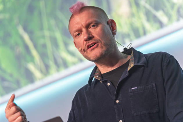 Berlin, 16.10.2026: Auf der NeulandPro Connect 2026 spricht der Publizist und Digital-Vordenker Sascha Lobo mit erhobener Hand zum Publikum. Die zweitägige KI-Konferenz NeulandPro Connect 2026 findet am 16. und 17. Oktober im Westhafen Event & Convention Center (WECC) in Moabit statt, einem historischen Speichergebäude am Berliner Westhafen. Veranstalter ist NeulandPro, eine Bildungs- und Medienmarke rund um Künstliche Intelligenz. Mit Vorträgen, Workshops und Hackathons richtet sich die Konferenz vor allem an kleine und mittelständische Unternehmen, Gründer und Führungskräfte, die KI praktisch einsetzen wollen; erwartet werden bis zu 1.000 Gäste. NeulandPro Connect 2026 - KI-Konferenz in Berlin
