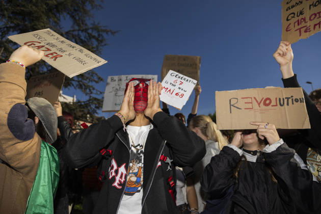 High Cost of Living Protest - Gap A masked demonstrator stands among young protesters holding signs in Gap, France, on October 17, 2026. A placard reads Trop jeune pour être écouté, assez grand pour se faire gazer ( Too young to be heard, old enough to be tear-gassed ). Photo by Thibaut Durand ABACAPRESS.COM Gap Provence-Alpes-Cote d Azur France  Copyright: xDurandxThibaut ABACAx