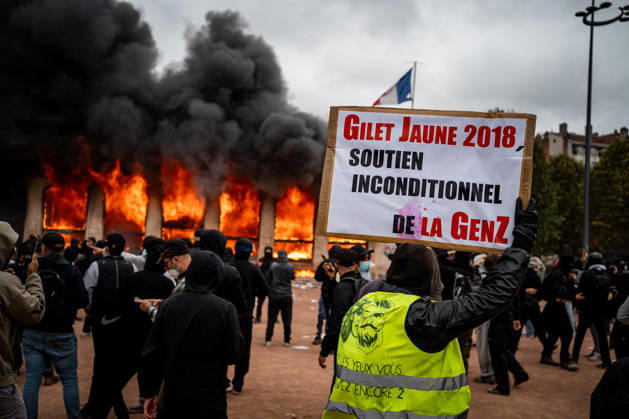 Protest against the high cost of living in Lyon on October 17, 2026 Nicolas Liponne MAXPPP Lyon 10 17 2026 A person wearing a yellow vest and holding a sign that reads Yellow Vest 2018, unconditional support from Gen Z, in front of the burning tourist office during the protest against the high cost of living in Lyon on October 17, 2026. Numerous clashes took place throughout the day between protesters and law enforcement. Several stores were looted, and some were set on fire in the city center A person wearing a yellow vest and holding a sign that reads Yellow Vest 2018, with unconditional support from Gen Z, stands in front of the burning tourist office during the protest against the high cost of living in Lyon on October 17, 2026. Nu  Copyright: xMAXPPPxNicolasxLiponnex NLP202610178895 NLP202610178895