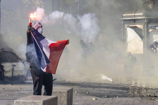 October 17, 2026, Paris, Å½Le-De-France, France: A masked demonstrator raises a lit flare while holding a French flag amid smoke and tear gas during protests in Paris, France, on October 17, 2026. Students and Yellow Vest protesters demonstrated over rising living costs and conditions in education. Paris France  - ZUMAl165 20261017_zip_l165_027 Copyright: xOrinxLouisx