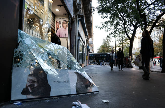 (261018) -- PARIS, Oct. 18, 2026 -- People walk past a shop damaged during a protest in Paris, France, Oct. 18, 2026. French President Emmanuel Macron on Sunday vowed legal action against those responsible for violence during protests across the country on Saturday. ) FRANCE-PARIS-PROTEST-VIOLENCE WuxHuiwo