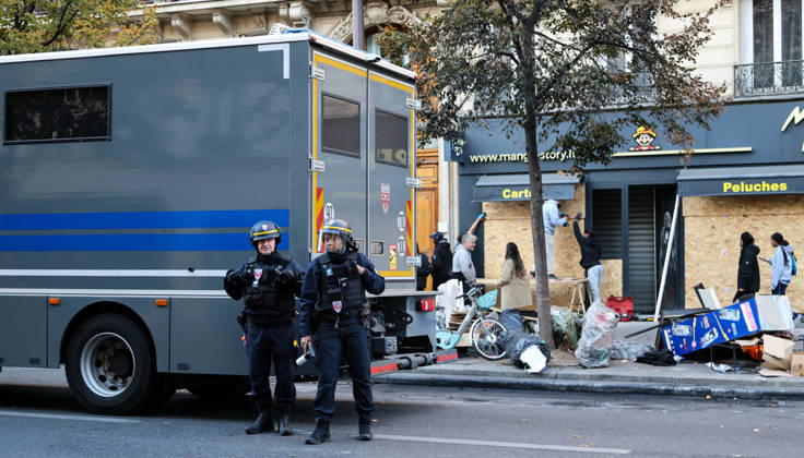 (261018) -- PARIS, Oct. 18, 2026 -- Law enforcement officers stand guard outside a shop in Paris, France, Oct. 18, 2026. French President Emmanuel Macron on Sunday vowed legal action against those responsible for violence during protests across the country on Saturday. ) FRANCE-PARIS-PROTEST-VIOLENCE WuxHuiwo 