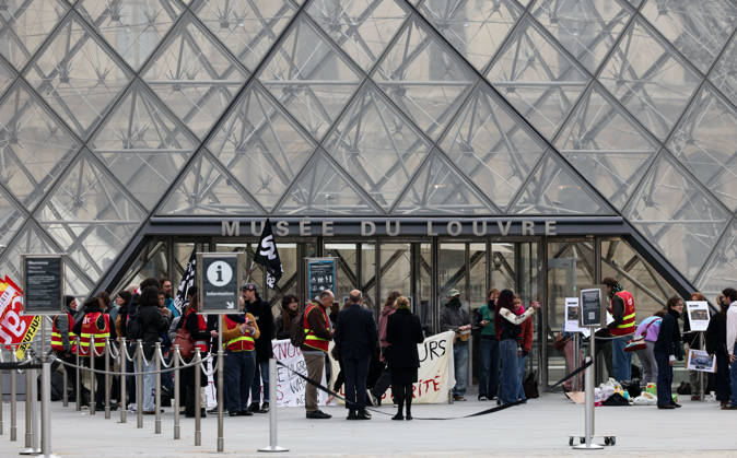 (261019) -- PARIS, Oct. 19, 2026 -- Protesters gather in front of an entrance to the Louvre Museum in Paris, France, Oct. 19, 2026. In Paris, the entrance to the Louvre Museum was blocked by student protesters on Monday morning, French daily Le Parisien reported, citing the museum s management and two trade unions. According to the trade union General Confederation of Labour, the museum would remain closed at least until noon. ) FRANCE-PARIS-LOUVRE MUSEUM-PROTEST WuxHuiwo 