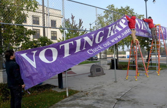 October 20, 2026, Racine, Wisconsin, USA: Workers put up a large banner announcing the start of voting as voters come to Racine City Hall Tuesday morning October 20, 2026 on the first day of early voting in Wisconsin for the midterm elections. There are two closely watched Congressional races, including the First District which includes Racine, and a contentious gubernatorial race on the ballot. Racine USA - ZUMAh154 20261020_znp_h154_004 Copyright: xMarkxHertzbergx