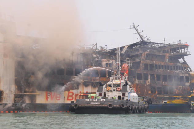 Efforts are underway to extinguish a fire that broke out on a passenger ferry in Indonesia s Cilegon PELABUHAN MERAK, CILEGON, INDONESIA - OCTOBER 21: Fireboats take turns spraying water onto the passenger ferry KMP Batumandi to cool down the vessel after it caught fire while preparing to dock off Merak Port in Cilegon, Banten, Indonesia on Wednesday, October 21, 2026. The vessel caught fire on Tuesday, October 20, and rescue operations remain underway as the ship continues to emit smoke. Water is continuously sprayed to cool the vehicle deck containing numerous cars, motorcycles, buses, and trucks, while authorities confirm no fatalities have been reported. Dasril Roszandi Anadolu Pelabuhan Merak Indonesia. Editorial use only. Please get Copyright: x2026xAnadoluxDasrilxRoszandix
