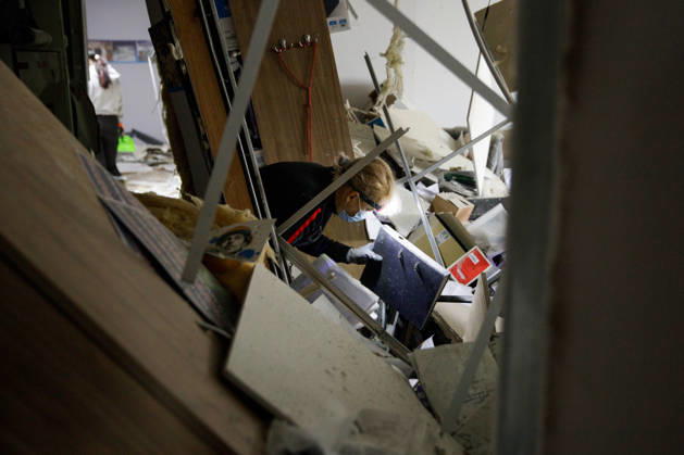A woman in a surgical mask and a headlight looks for goods that can be salvaged after a Russian attack in an Epicentr K home improvement hypermarket in the Obolonskyi district, Kyiv, Ukraine, October 22, 2026. On Thursday night, Russian forces struck the Ukrainian capital with ballistic missiles and drones. According to the Kyiv City Military Administration, six districts came under attack. One person was killed, 24 were injured, and 16 of them were hospitalised. (Photo by Marianna Kotyk Ukrinform) Russian attack destroys shops in Kyiv  Copyright: xMariannaxKotykx