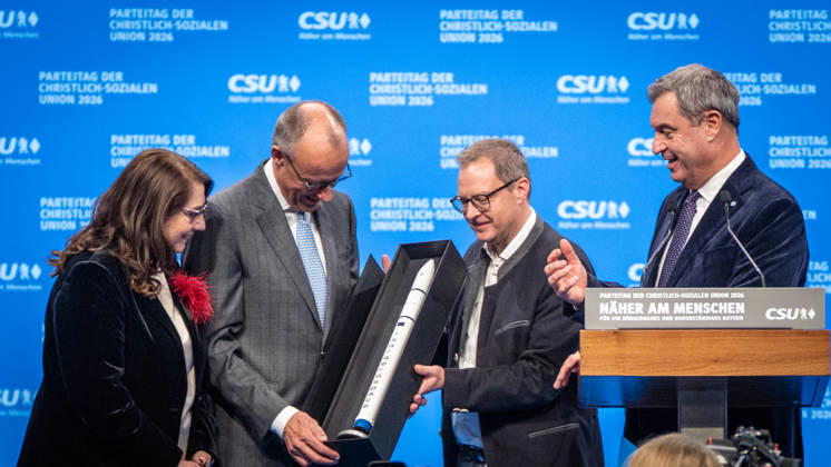 Bundeskanzler Friedrich Merz mit dem CSU-Parteivorsitzenden Markus Söder auf dem Parteitag, mit Tanja Schorer-Dremel und Martin Huber bei der Übergabe einer Rakete als Modell an den Bundeskanzler;Parteitag der CSU in München, München Bayern Deutschland Messegelände München