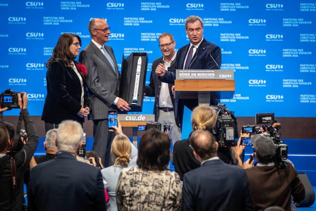 Bundeskanzler Friedrich Merz mit dem CSU-Parteivorsitzenden Markus Söder auf dem Parteitag, mit Tanja Schorer-Dremel und Martin Huber bei der Übergabe einer Rakete als Modell an den Bundeskanzler;Parteitag der CSU in München, München Bayern Deutschland Messegelände München