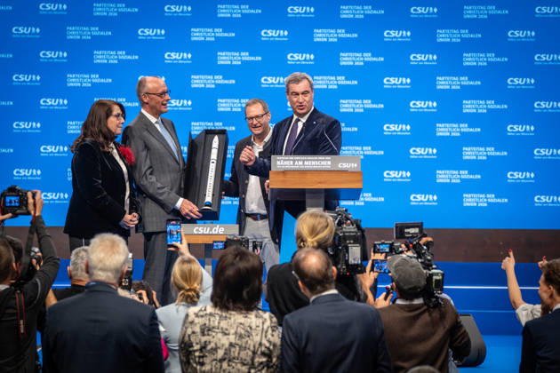 Bundeskanzler Friedrich Merz mit dem CSU-Parteivorsitzenden Markus Söder auf dem Parteitag, mit Tanja Schorer-Dremel und Martin Huber bei der Übergabe einer Rakete als Modell an den Bundeskanzler;Parteitag der CSU in München, München Bayern Deutschland Messegelände München